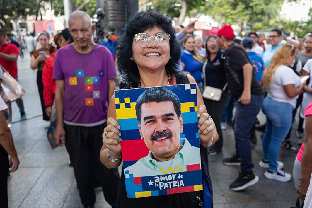 Женщина держит портрет президента Венесуэлы Николаса Мадуро