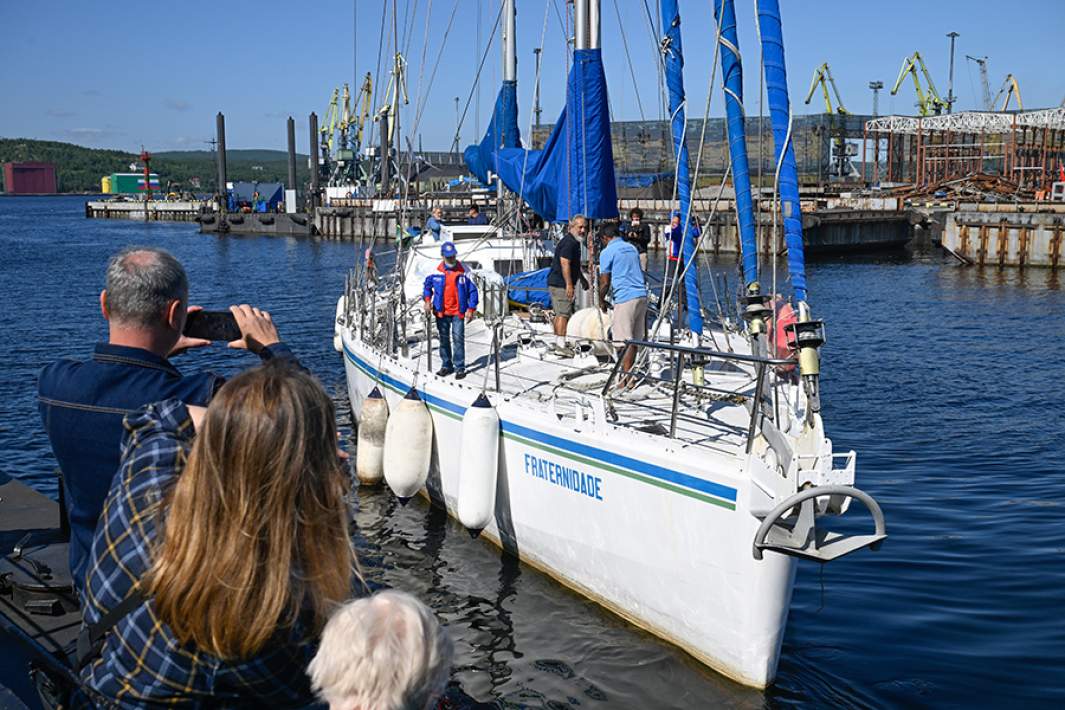 Яхта Fraternidade с российско-бразильским экипажем Международной кругосветной парусной экспедиции «Братство-2025» покидает место стоянки около атомного ледокола «Ленин», чтобы далее пройти Северным морским путем. Мурманск, 15 июля 2025 года