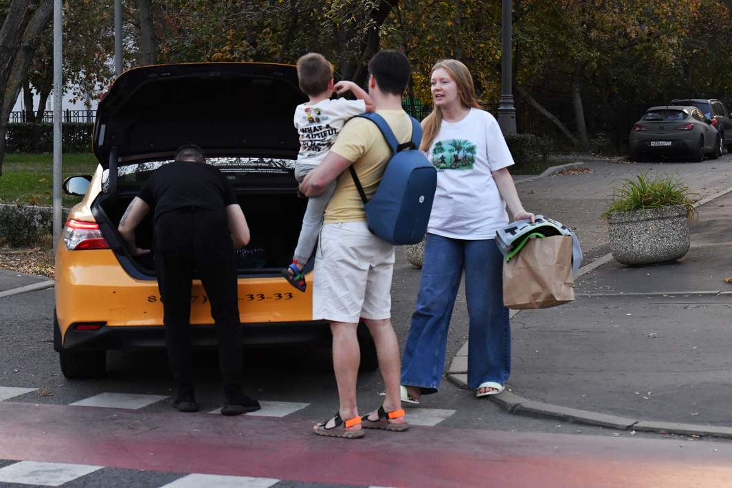 Семья с ребенком садится в такси