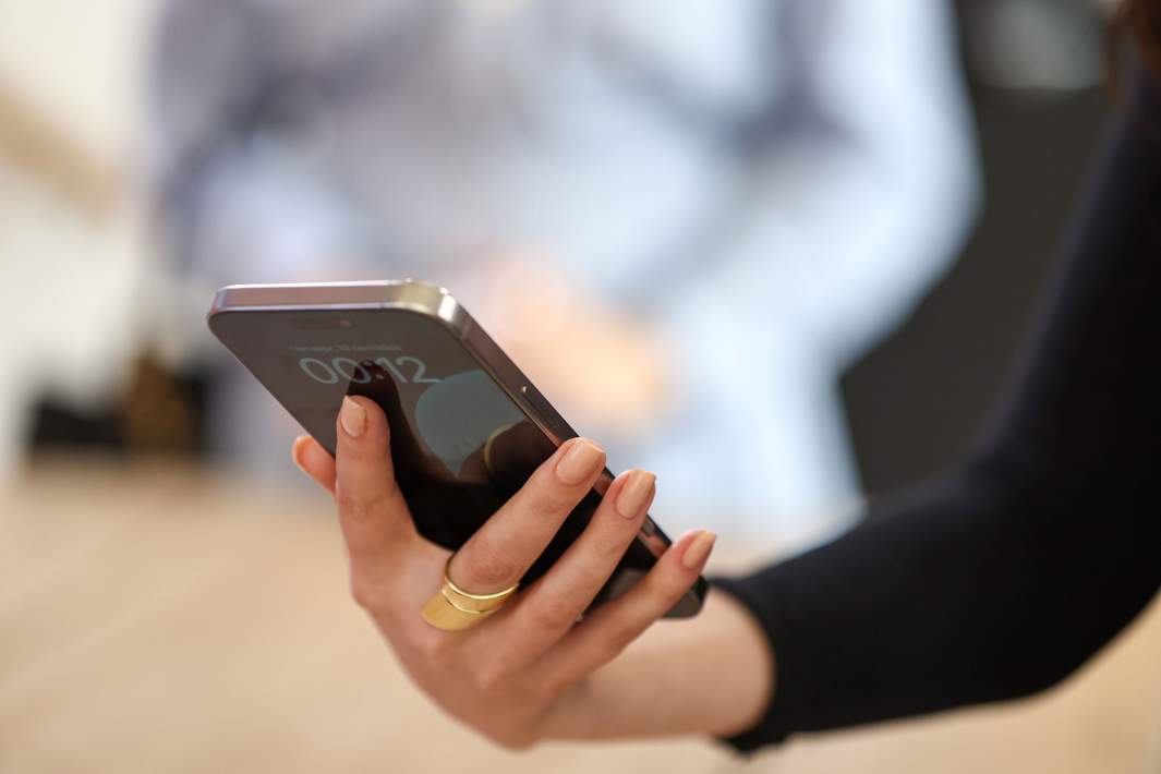 Женщина держит в руках айфон 