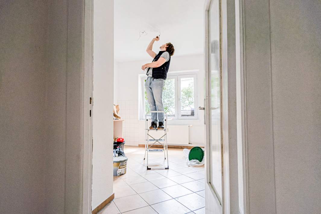 Мужчина красит потолок 