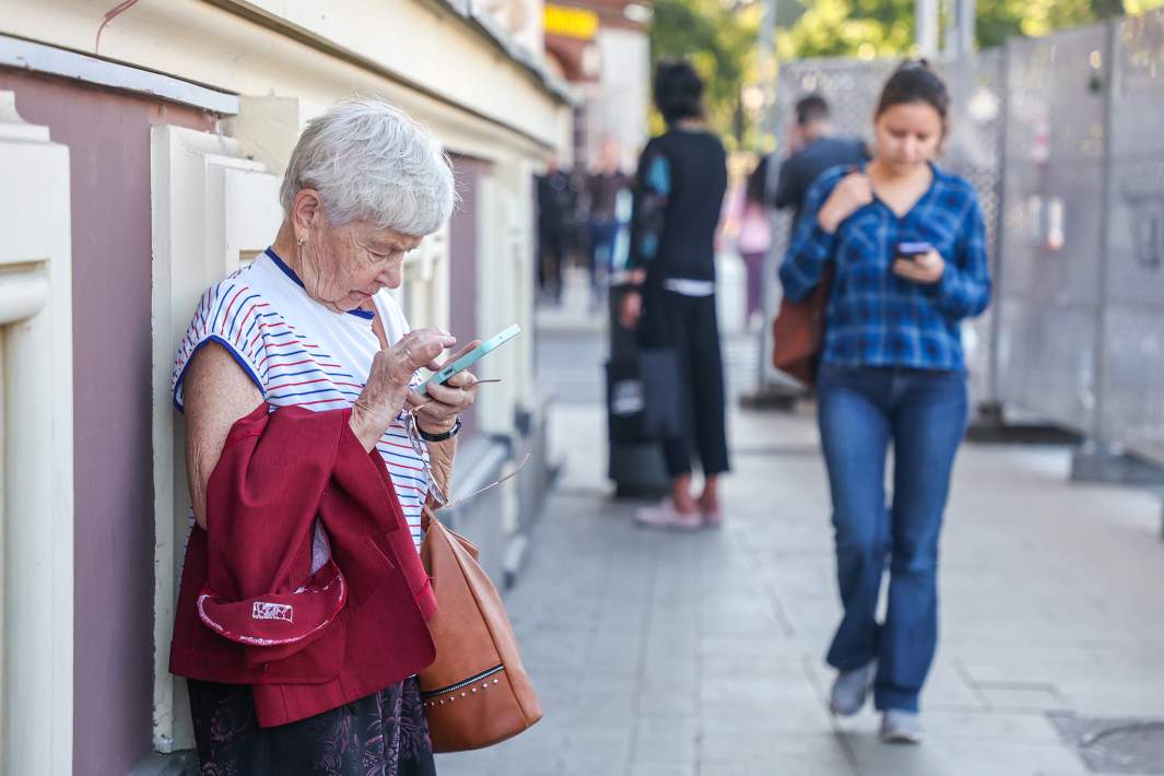 Пенсионер смотрит в телефон 