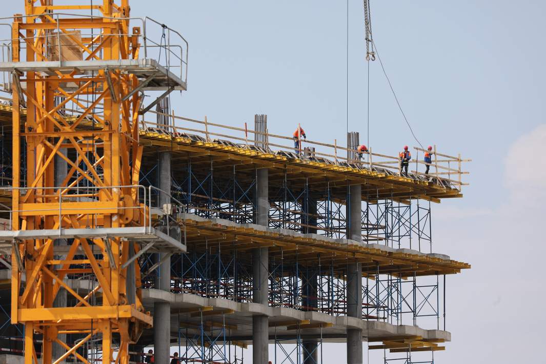 Башенный кран на фоне стройки 