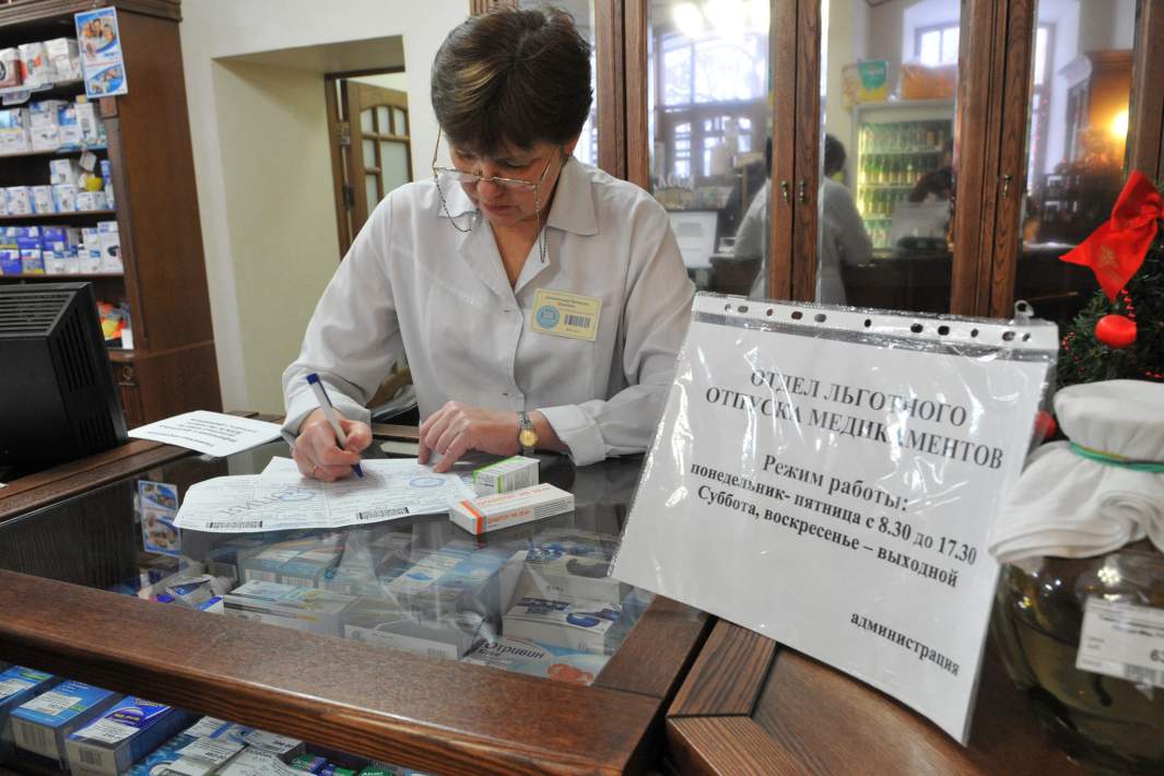 Фармацевт во время сортировки лекарственных препаратов в аптеке