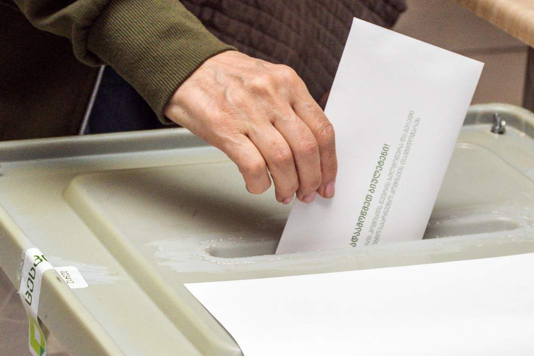 Избиратель опускает бюллетень в урну на выборах президента Грузии на одном из избирательных участков в Тбилиси