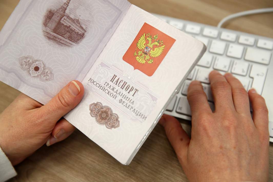 Паспорт в ркуах мужчины за компьютером