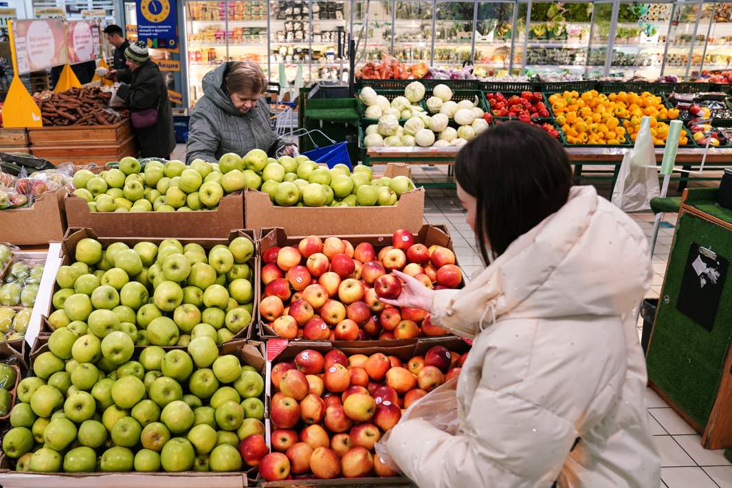 Покупатель выбирает яблоки в магазине