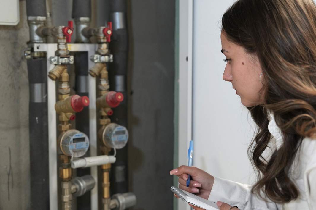 Девушка снимает показания счетчиков воды