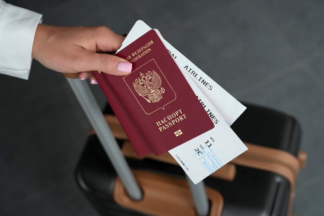 Заграничный паспорт и посадончые талоны в руке девушки