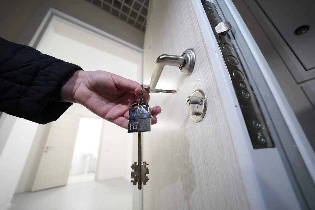 Женщина открывает дверь квартиры 