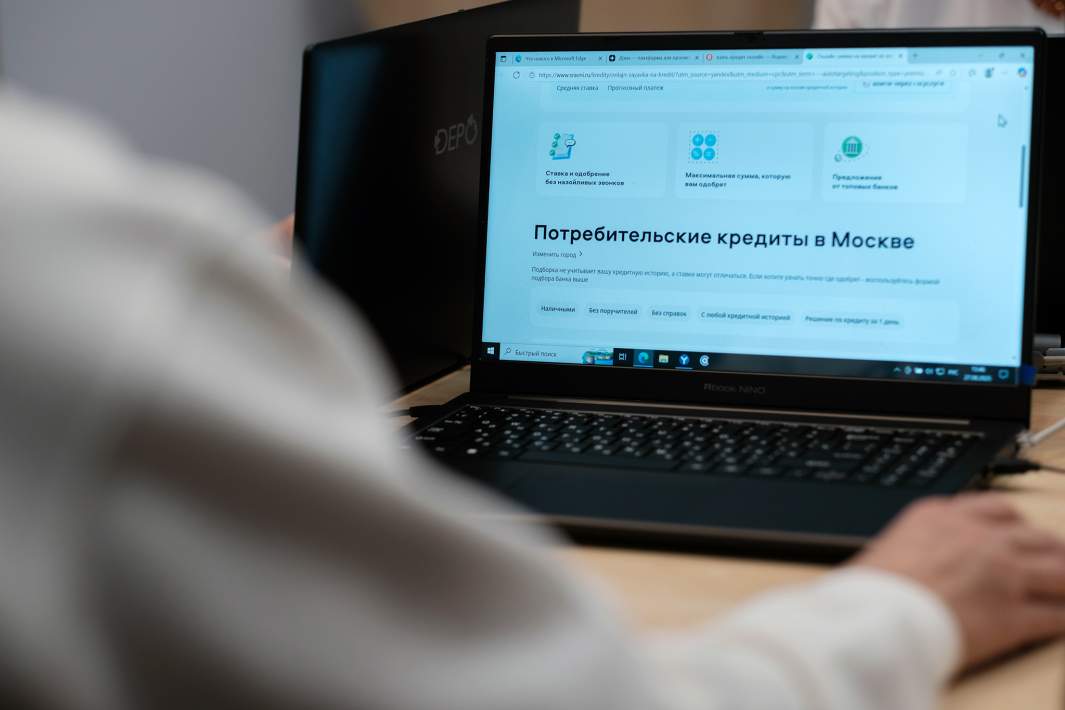 Пожилая женщина использует сайт для сравнения потребительских кредитов на ноутбуке