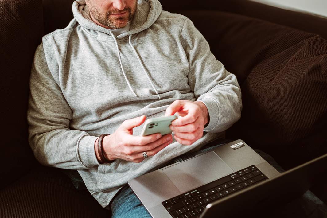 Мужчина со смартфоном и ноутбуком