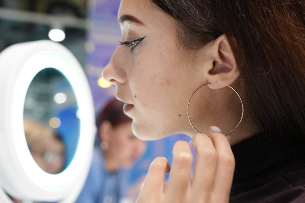 Девушка меряет сережки 