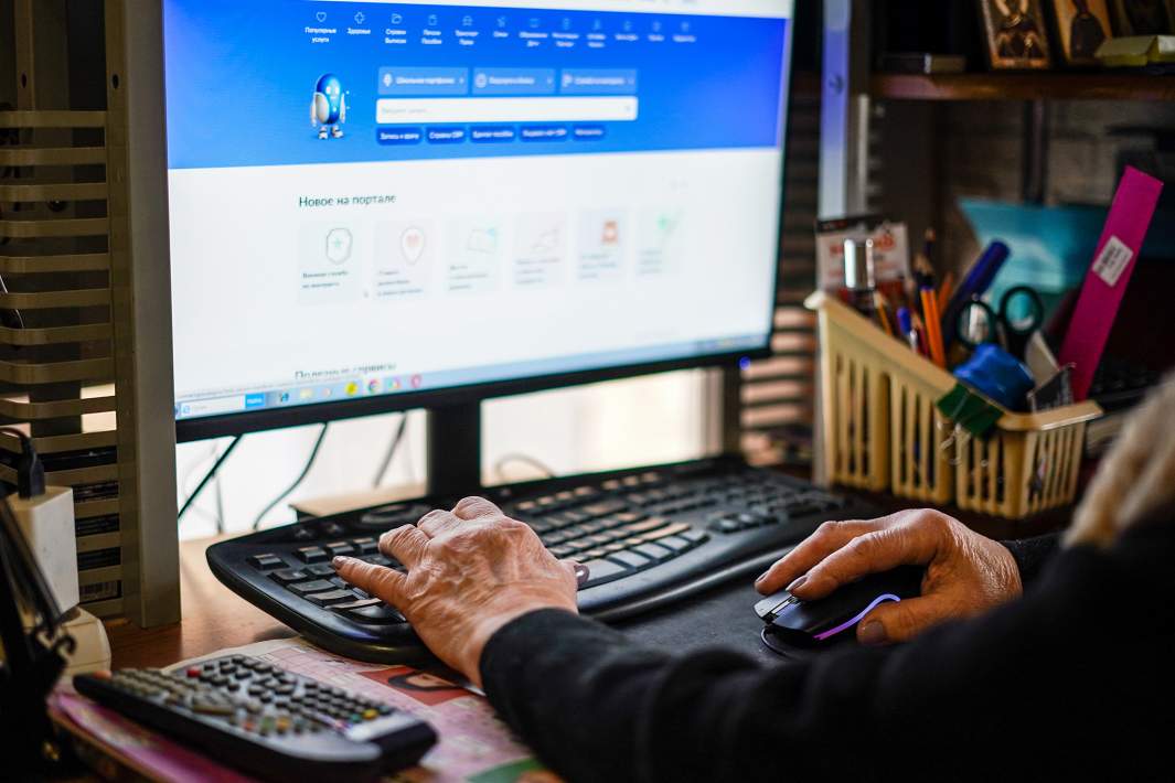 Женщина пенсионного возраста сидит за компьютером