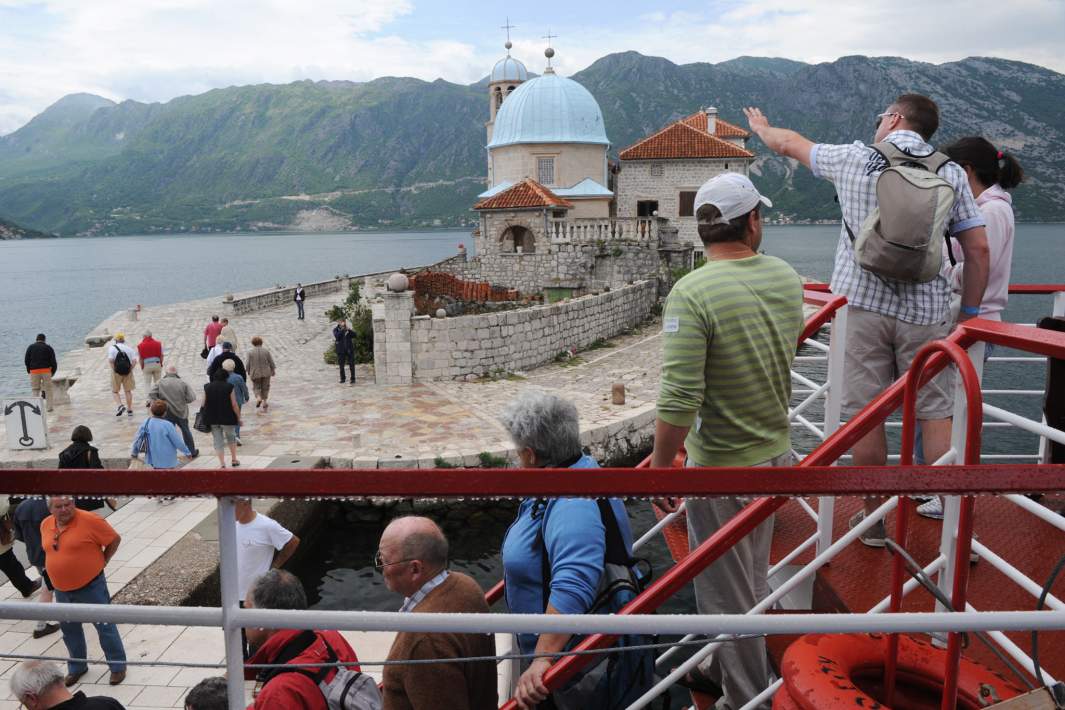 Туристы у храма Богородицы на Рифе близ города Пераста в Черногории