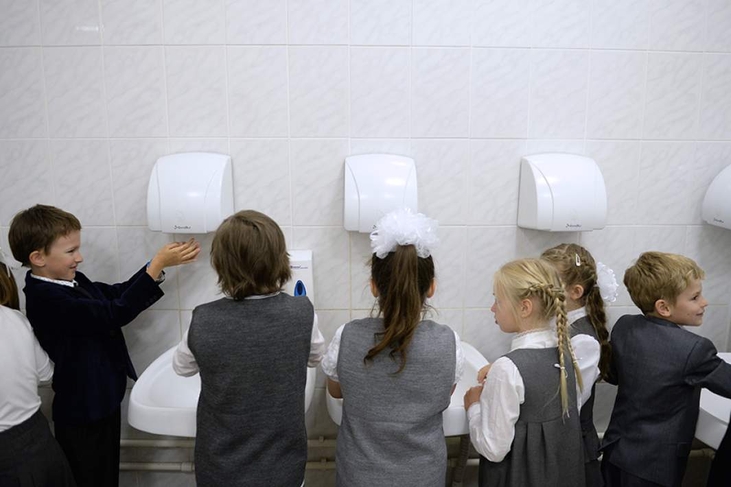 Первоклассники моют руки перед обедом в одной из школ