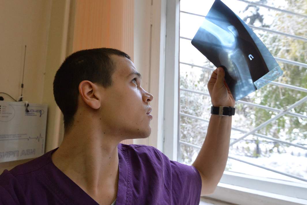 Врач-травматолог смотрит на рентгеновский снимок в травмпункте