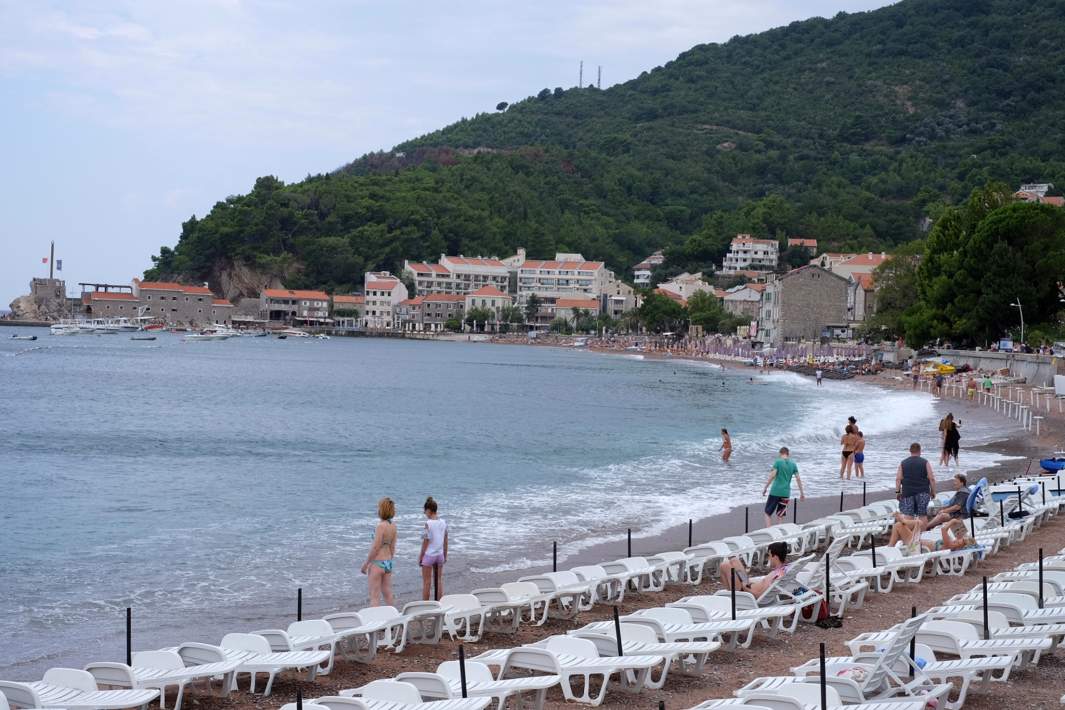 Отдыхающие на пляже в Петроваце в Черногории