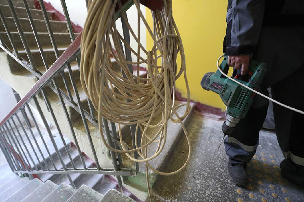 Рабочий во время одного из этапов капитального ремонта жилого дома