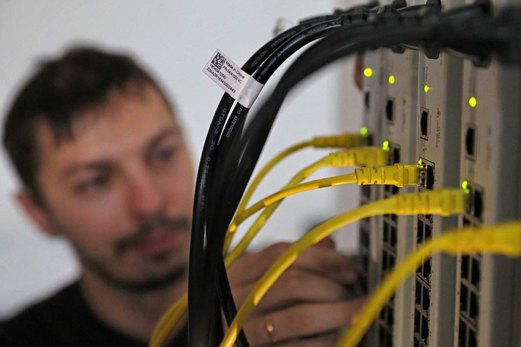 Сотрудник компании интернет-провайдера во время настройки сетевых коммутаторов