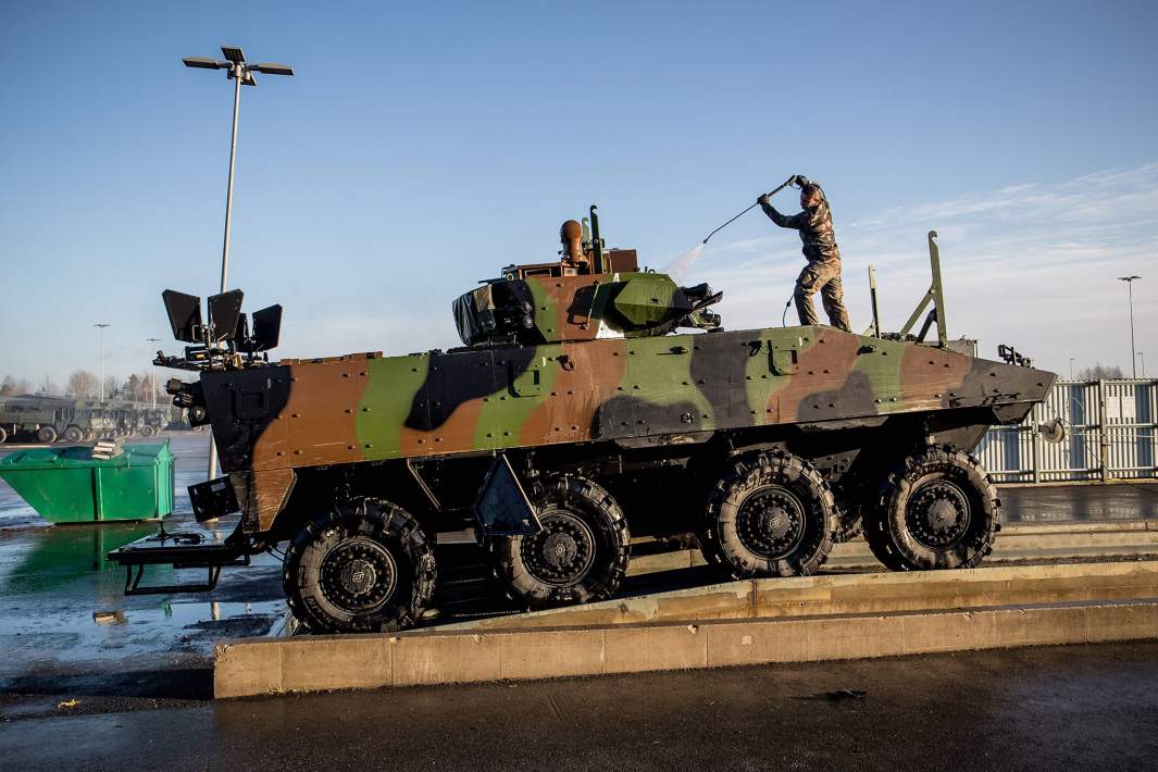 Солдат моет бронемашину 