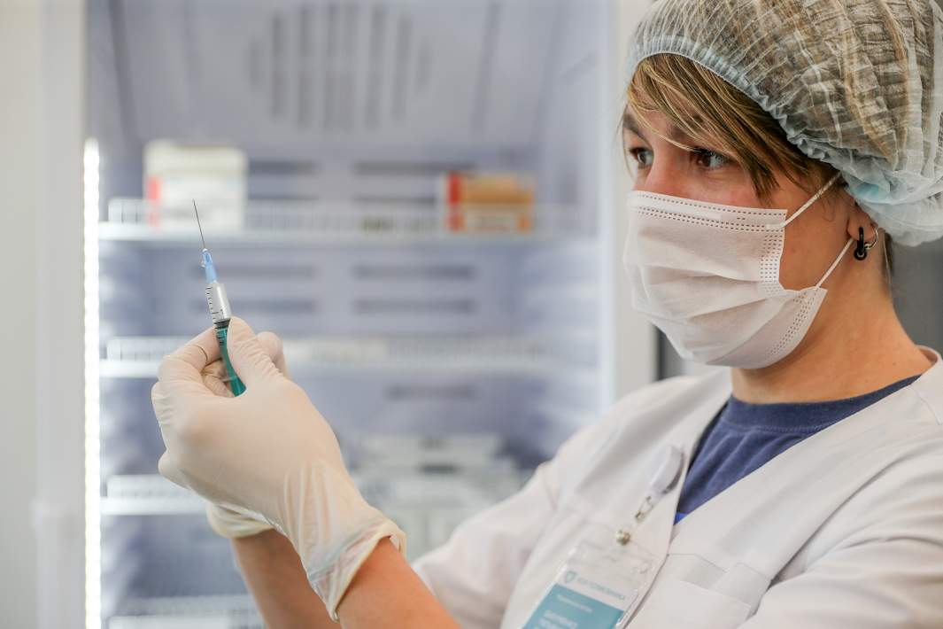 Врач держит шприц с вакциной 