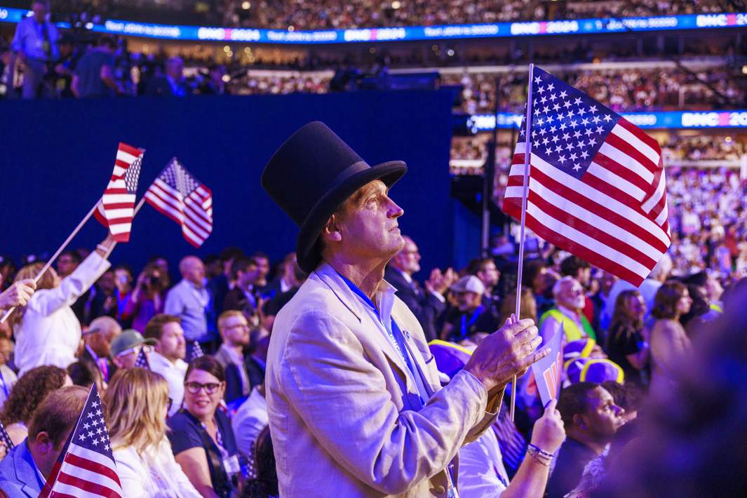 Делегат в цилиндре держит американский флаг в четвёртый день Национального съезда Демократической партии