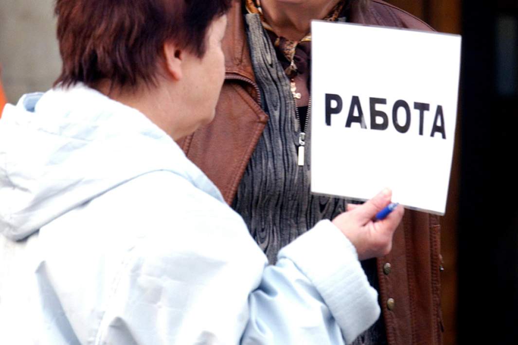 Женщина держит табличку с надписью «Работа»