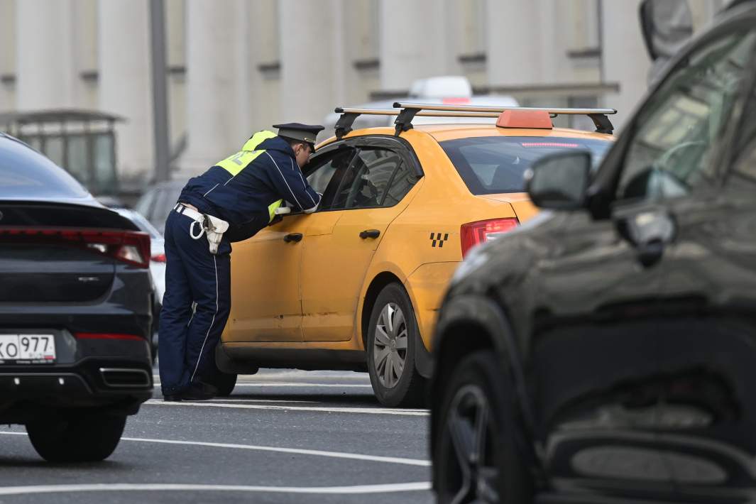 Инспектор ДПС проверяет документы у водителя такси