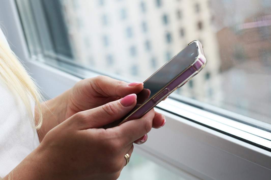 Женщина держит телефон в руках 