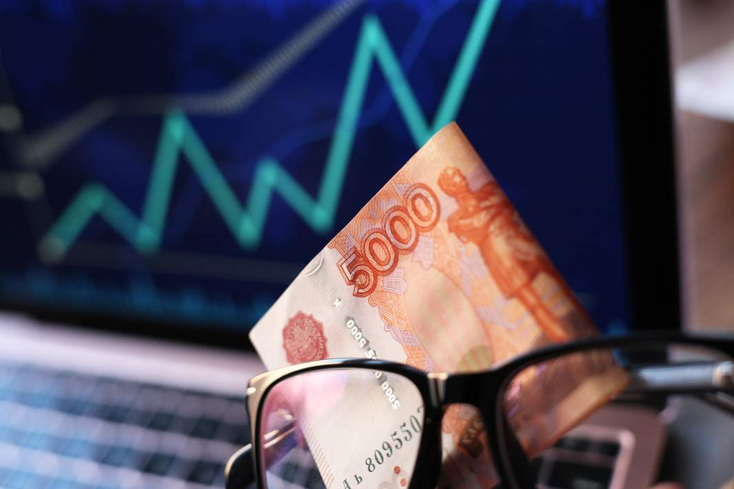 Рублевые купюры на фоне графика 