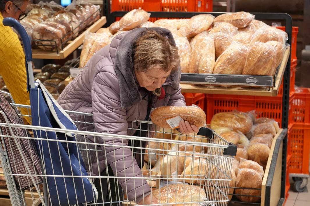Женщина покупает хлеб 