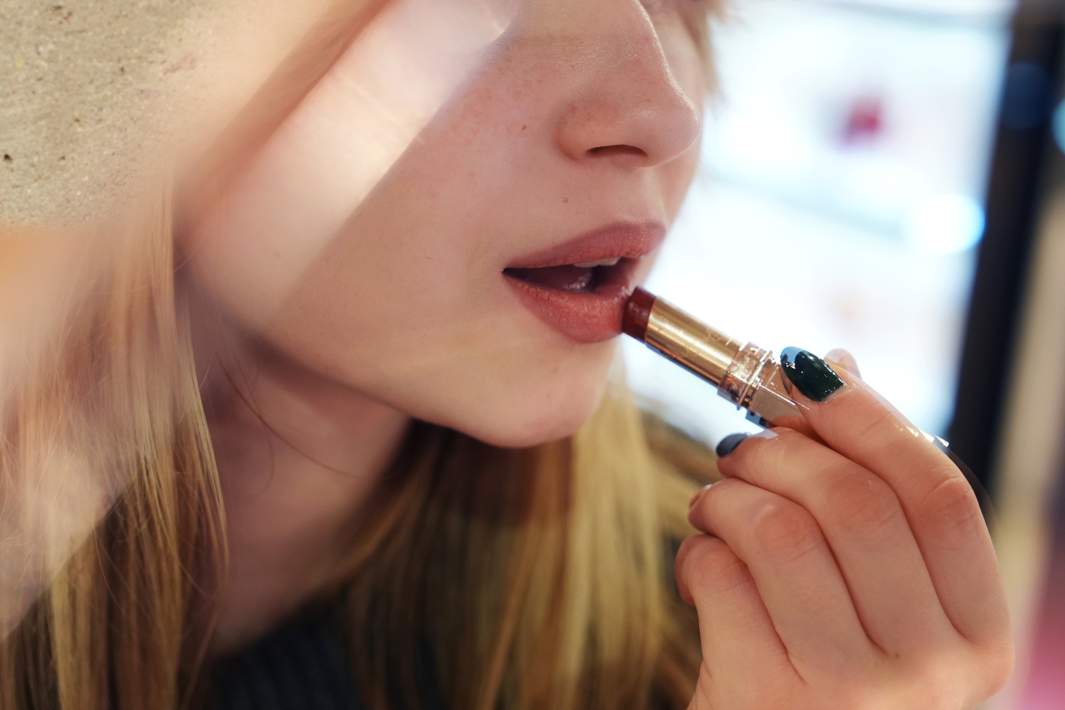 Женщина красит губы 