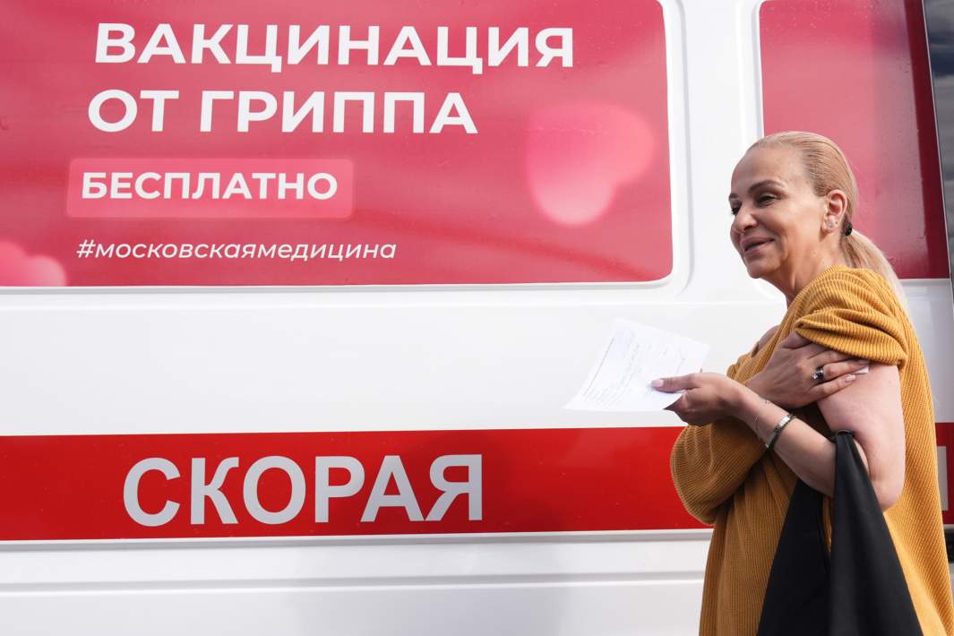 Женщина на фоне автомобиля скорой помощи 