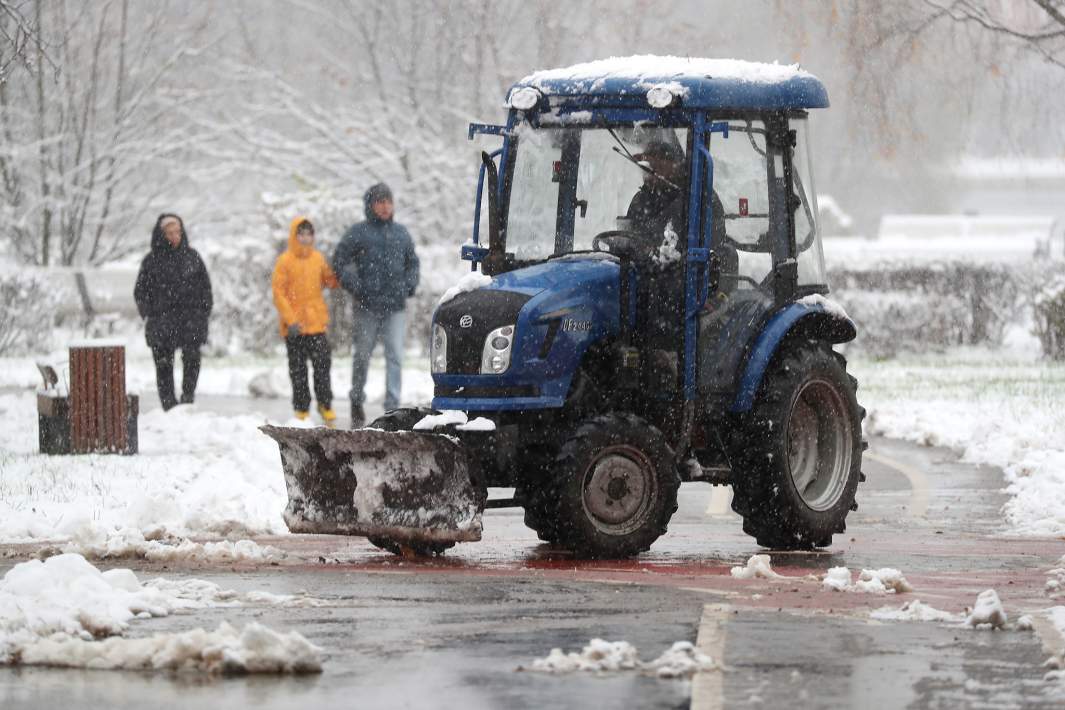 Сотрудники коммунальных служб убирают улицы после снегопада
