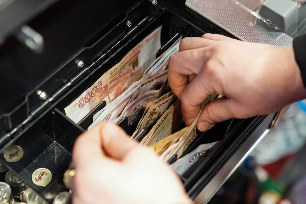 Кассир выдает сдачу в магазине розничной торговой сети