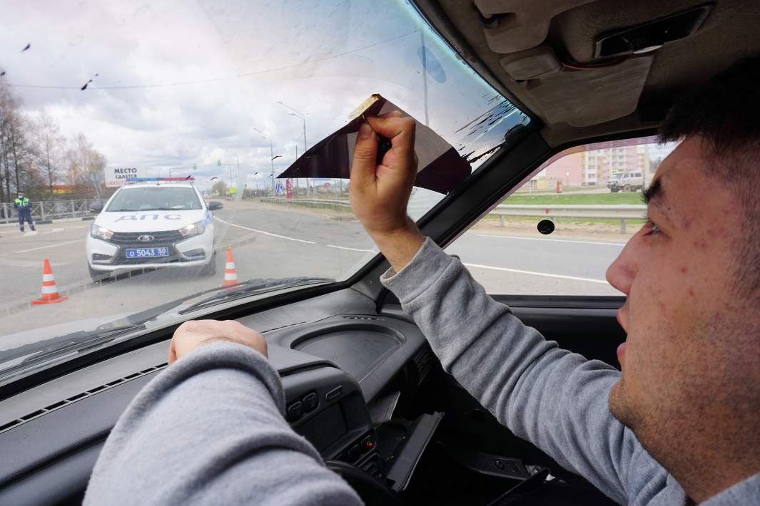 Мужчина удаляет тонировку лобового стекла