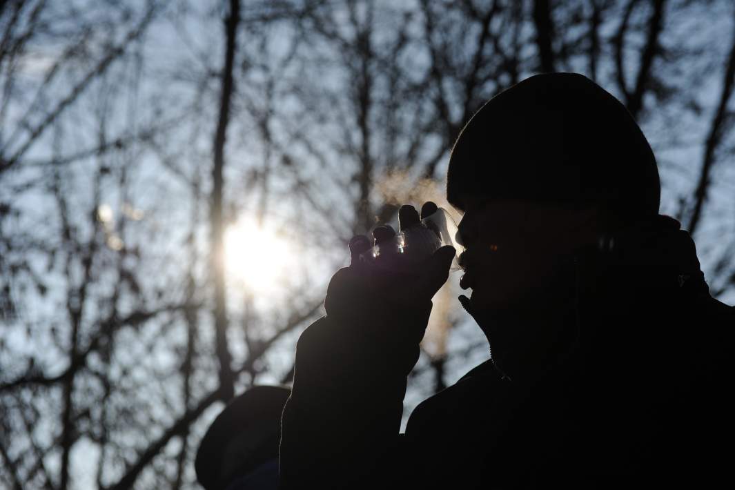 Мужчина пьет напиток на улице