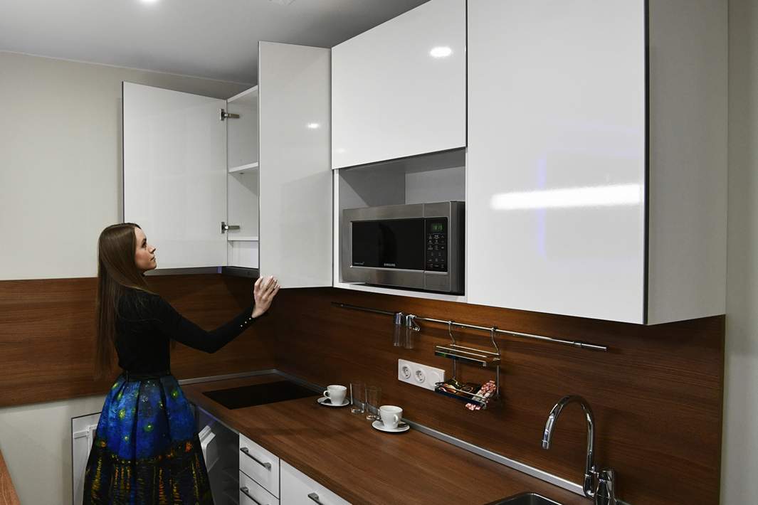 Девушка осматривает кухню 