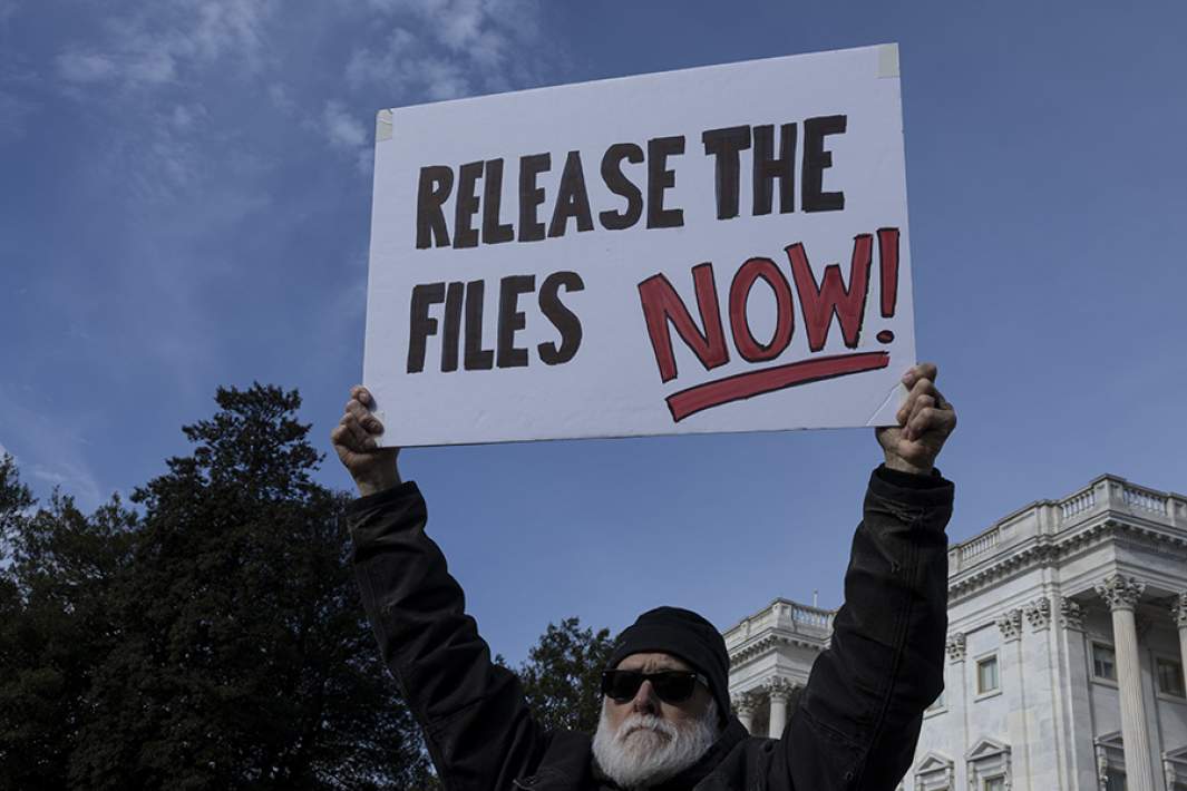 Протестующий с плакатом рядом с Капитолием 