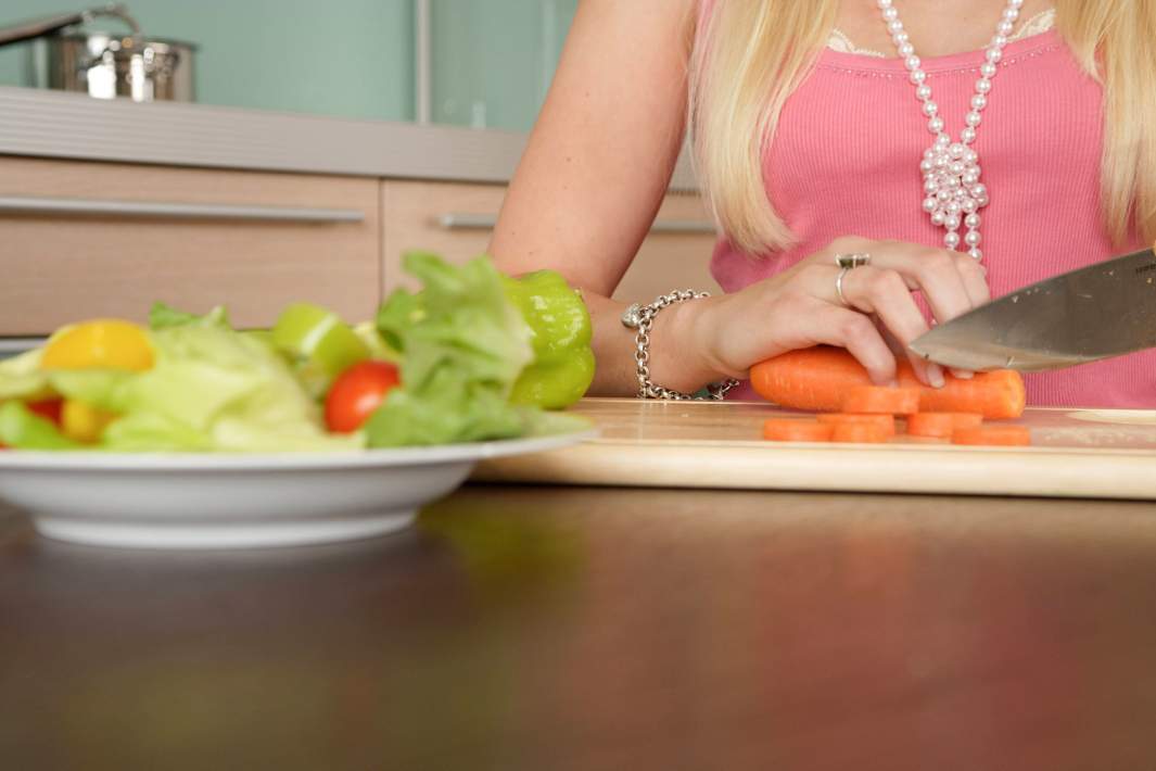 Женщина режет овощи