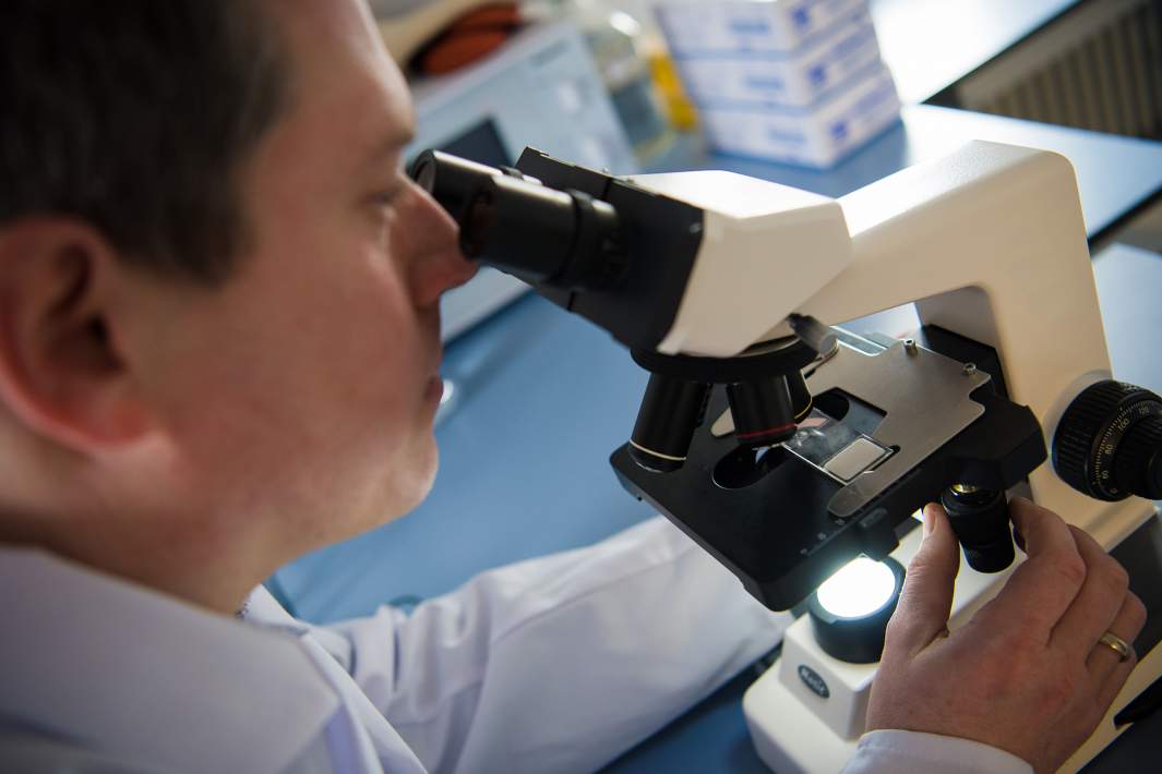 Ученый смотрит в микроскоп 