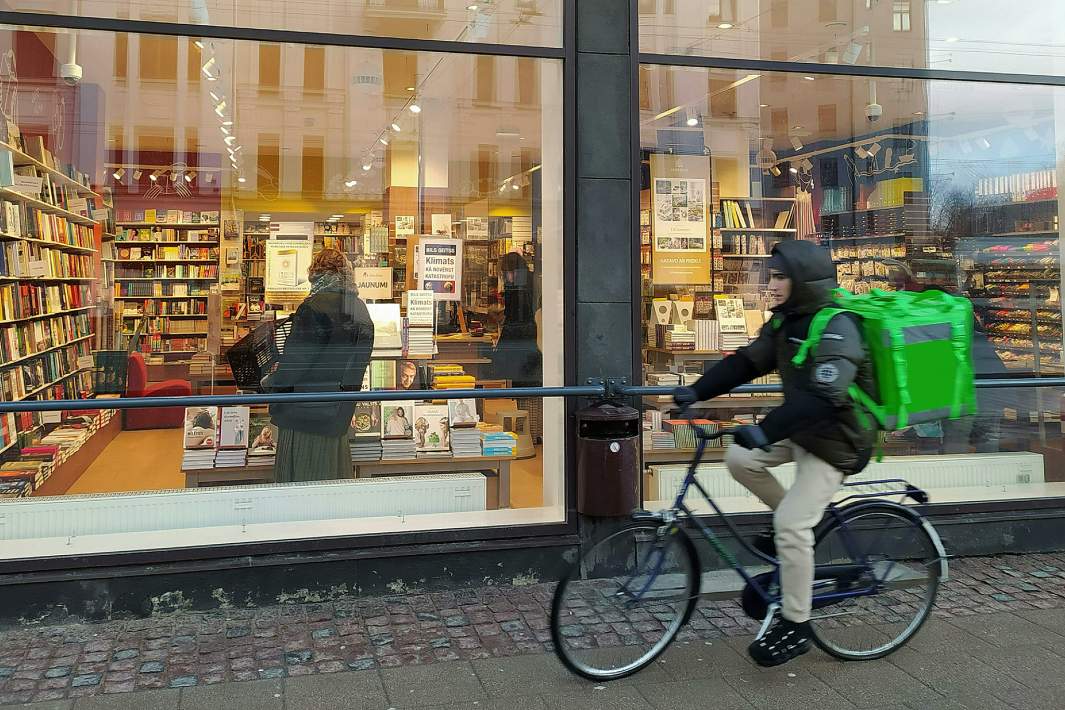 Велокурьер проезжает мимо книжного 