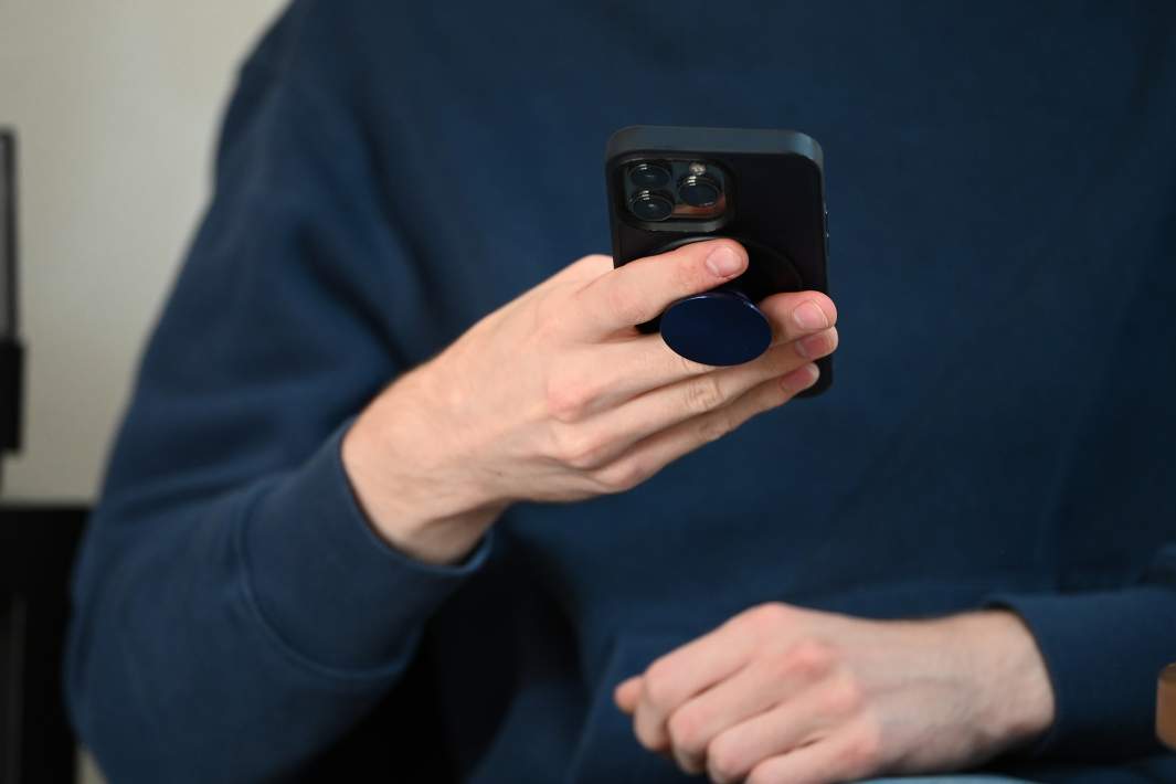 Мужчина держит в руках телефон 