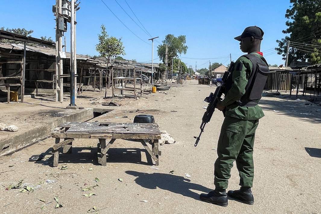 Нигерийский полицейский стоит на страже у мечети Аль-Адум Джумаат на следующий день после взрыва, прогремевшего в мечети после вечерней молитвы возле рынка Гамбору в Майдугури