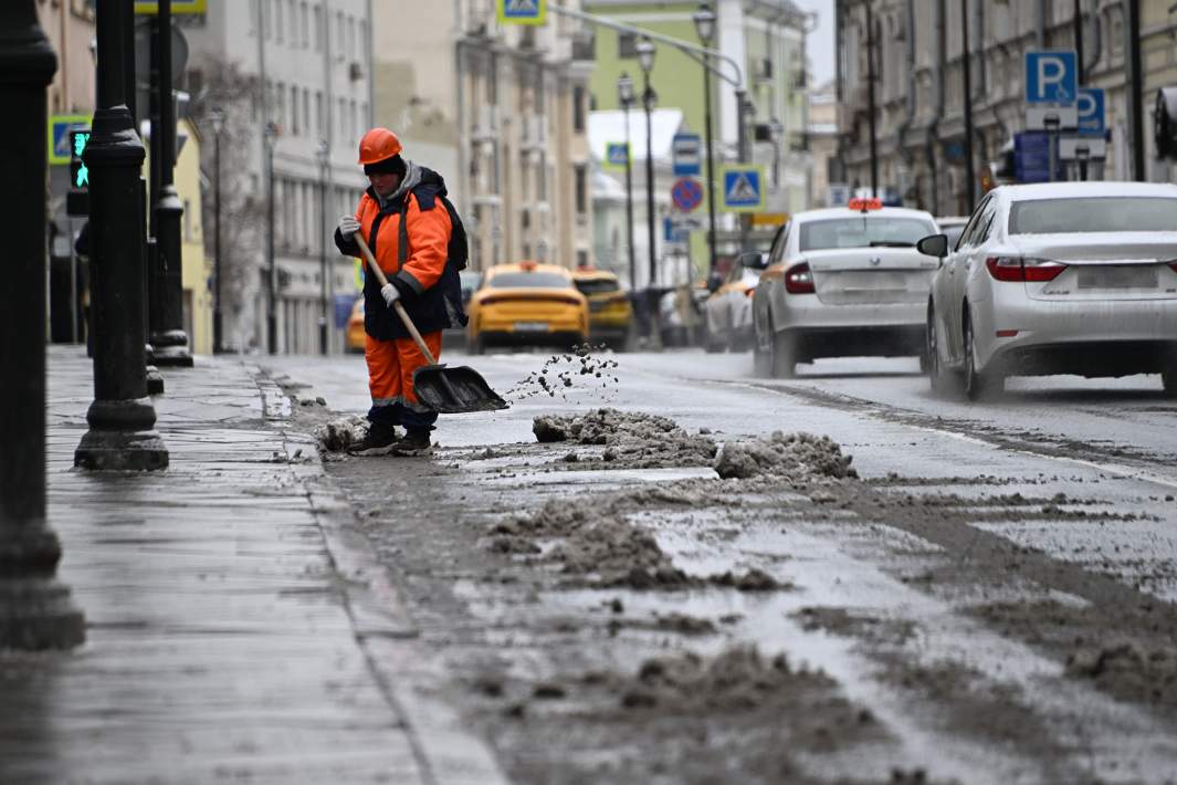 Дворник чистит снег на дороге 