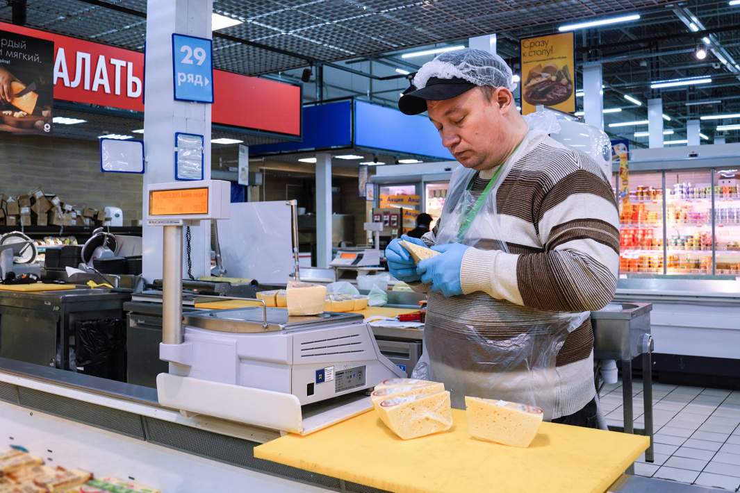 Мужчина наклеивает ценники 