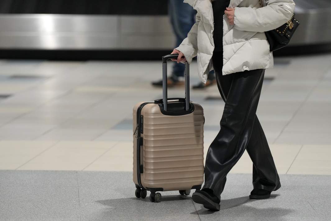 Пассажир с чемоданом в международном аэропорту