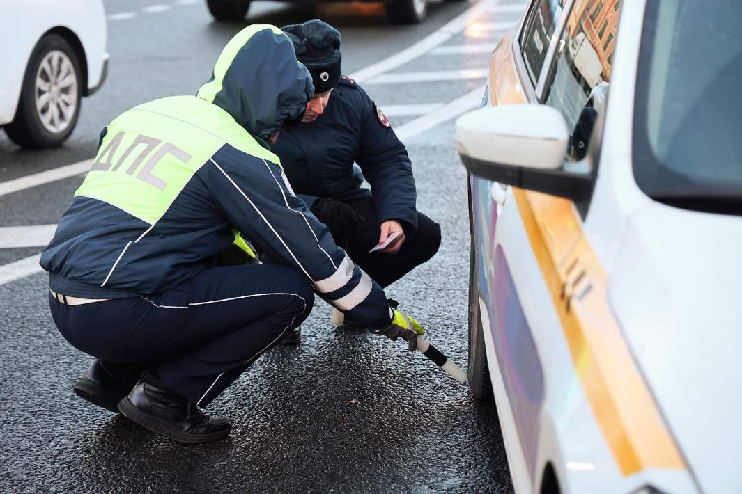 Сотрудники ДПС изучают шины автомобиля 