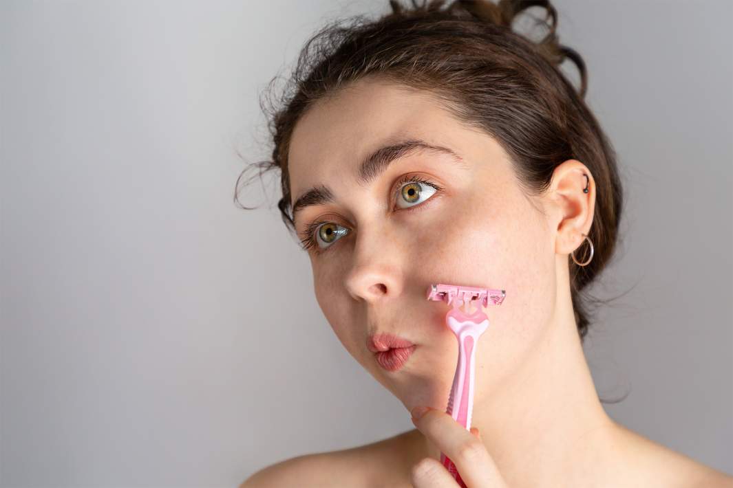 девушка бреет лицо